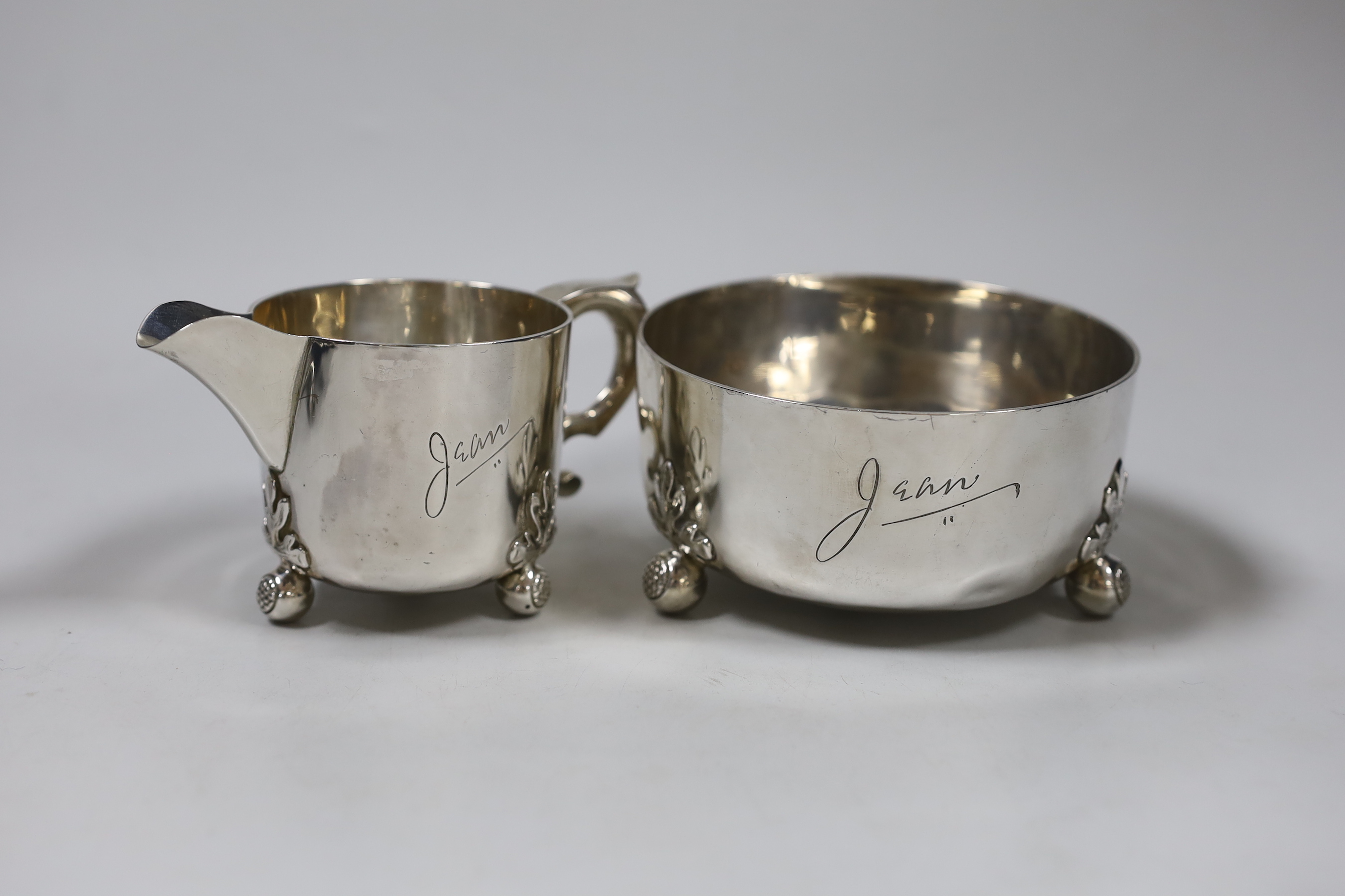 An Edwardian silver cream jug and sugar bowl, on ball feet, by William Comyns, London, 1907, bowl diameter 12,3cm, 12.2oz.